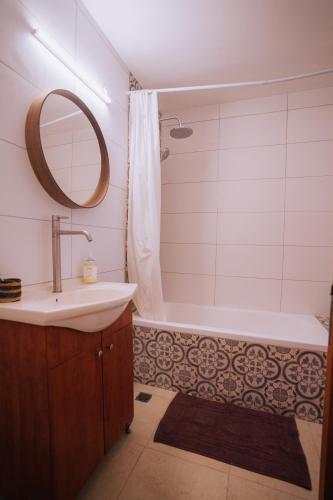 a bathroom with a sink and a tub and a mirror at סלעית 8 in Mitzpe Ramon
