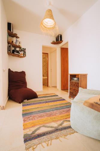 a living room with a bed and a rug at סלעית 8 in Mitzpe Ramon
