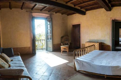 a bedroom with a bed and a couch and a window at Villa Bottini ideale per relax di lusso in Robecco dʼOglio