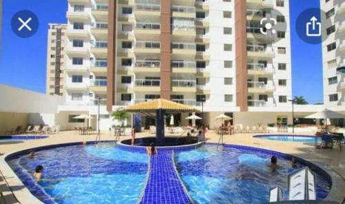 a large swimming pool in front of a large building at Apto confortável Grand Reserva Casa da Madeira! in Caldas Novas