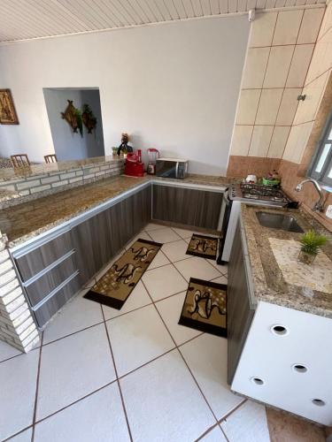 a kitchen with a sink and a tiled floor at Casa Família Sander in Imbé
