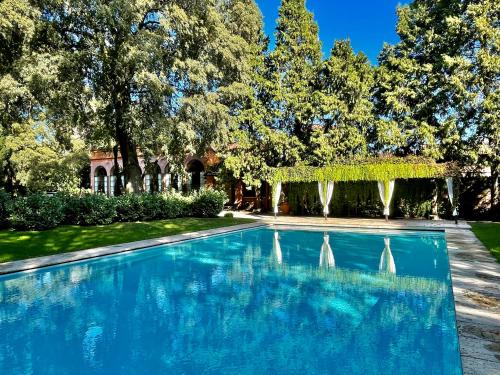 a swimming pool in front of a house with trees at Villa Bottini ideale per relax di lusso in Robecco dʼOglio