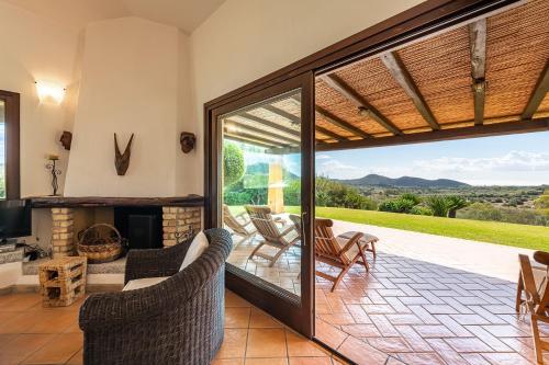 a living room with a fireplace and a patio at Villa Anna Maria in Villasimius