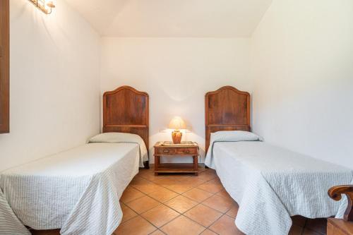 a room with two beds and a table with a lamp at Villa Anna Maria in Villasimius