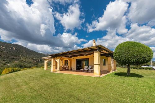 a small yellow house with a large yard at Villa Anna Maria in Villasimius