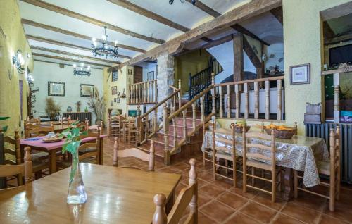 ein Esszimmer mit einem Tisch, Stühlen und einer Treppe in der Unterkunft Casa Rural Garrido in Ademuz