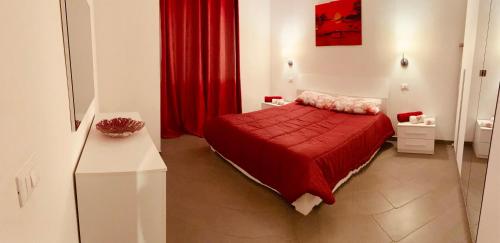 ソットマリーナにあるCasa Normaのベッドルーム1室(赤いベッド1台、赤いカーテン付)