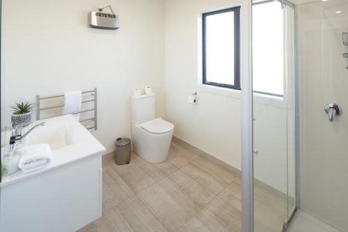 a white bathroom with a toilet and a sink at Alpine View Apartment 1 - Tekapo in Lake Tekapo