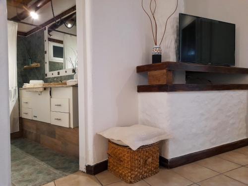 a living room with a television and a wicker stool at Casona en Bodega Centenaria in Guaymallen