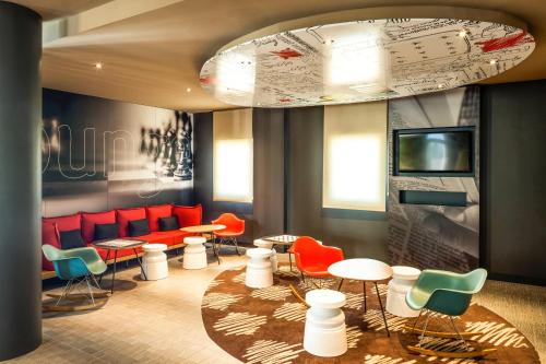a waiting room with colorful chairs and tables at Ibis Sevilla in Seville