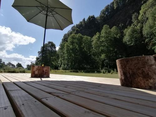 an umbrella sitting on top of a wooden table at Parque Relicura in Palguín