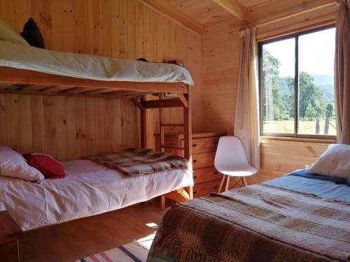 a bedroom with two bunk beds and a window at Parque Relicura in Palguín