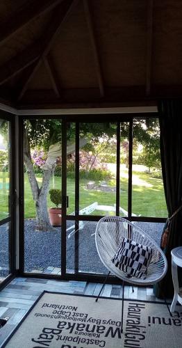 a patio with two chairs and a view of a yard at Blue Stone in Timaru