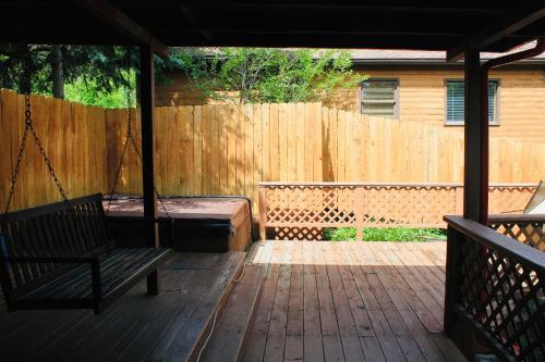 a porch with a swing and a wooden fence at Foot of the Mountain Motel in Boulder