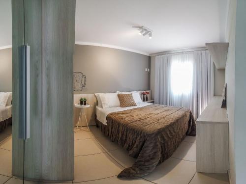 ein Schlafzimmer mit einem Bett und einem Fenster in der Unterkunft Apto temático Cerveja - Pomerode SC in Pomerode