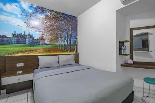 a bedroom with a large bed and a tv at Green Stay Inn Aeropolis in Tangerang