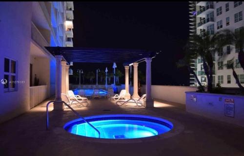 a hot tub in the middle of a patio at night at Brickell Apartments with Oceanview in Miami