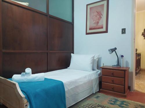 a bedroom with a bed and a table with a lamp at Suite Simples Boa Barata 10 min Metro e Aeroporto CGH in Sao Paulo