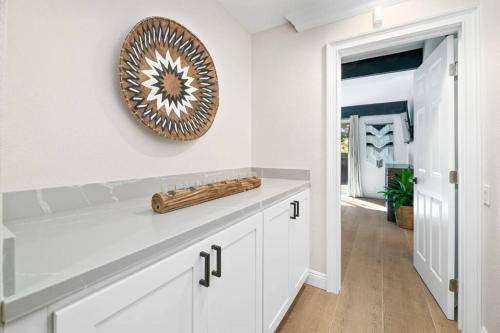 eine Küche mit weißen Schränken und einem Spiegel an der Wand in der Unterkunft Modern Split Level Cabin -Hot Tub & Game Room in Big Bear City