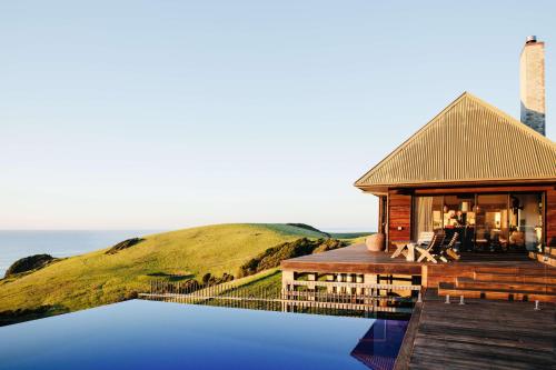 a house with a reflection in the water at Ocean Farm in Gerringong