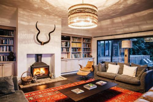 a living room with a couch and a fireplace at Ocean Farm in Gerringong