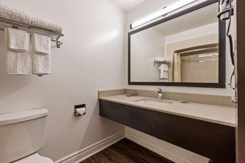 ein Bad mit einem Waschbecken und einem Spiegel in der Unterkunft SureStay Hotel by Best Western Kemptville in Kemptville
