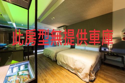 two beds in a room with chinese writing on the wall at TY Motel in Dayuan
