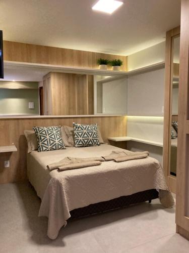 1 dormitorio con 1 cama grande con almohadas azules en Residence Farol - Loft 213 en Laguna