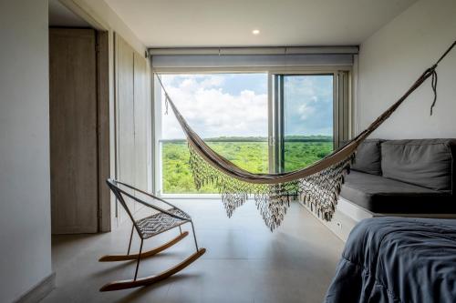 a hammock in a bedroom with a large window at Morros ío Serena Del Mar - RNT 95283-523 in Cartagena de Indias