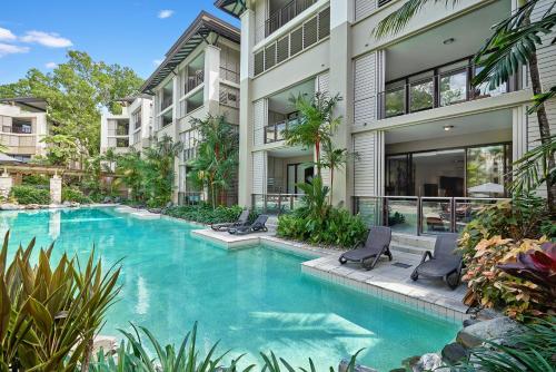 a swimming pool in front of a building at Swim Out Apartments in Triton Street Beachfront Resort Palm Cove in Palm Cove