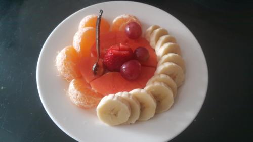 a white plate of fruit with bananas and strawberries at Abadia de Tomine in Guatavita