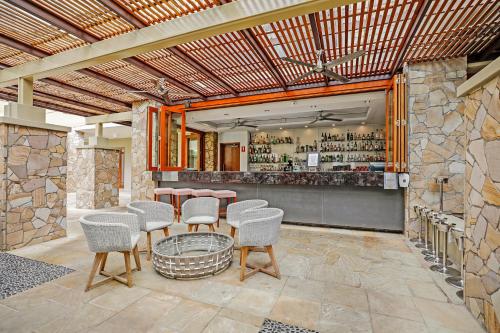 a bar with chairs and a table in a room at Swim Out Apartments in Triton Street Beachfront Resort Palm Cove in Palm Cove