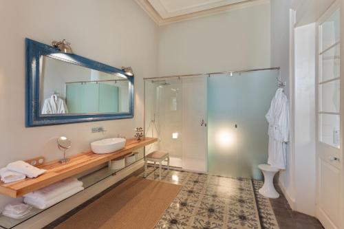 a bathroom with a sink and a shower with a mirror at Jardí de Ses Bruixes Boutique Hotel in Mahón