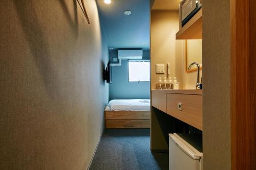 boxi Hakata 2 في فوكوكا: حمام صغير مع سرير ومغسلة