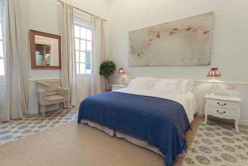 a bedroom with a bed and a painting on the wall at Jardí de Ses Bruixes Boutique Hotel in Mahón