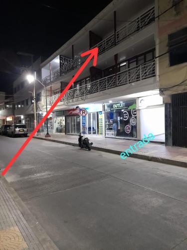 a red arrow points to a person sitting on the side of a street at Aptos Majos centro in San Andrés