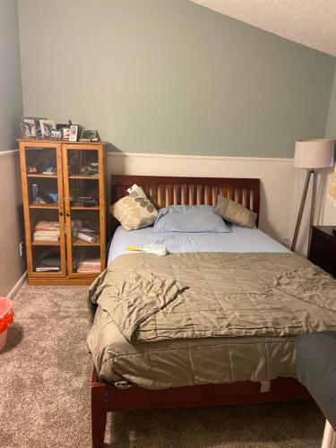 a bedroom with a bed and a wooden cabinet at COMFY COZY ROOM ON QUIET CUL-DE-SAC in Los Angeles