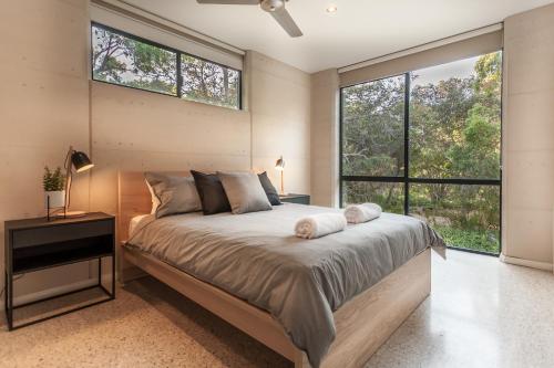 a bedroom with a bed and a large window at Carpe Vino - quiet bushland home, Margaret River in Margaret River Town