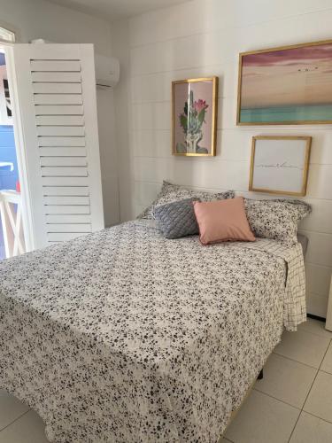 a bedroom with a bed with a floral bedspread at Casa condomínio 2 suítes in Juazeiro do Norte