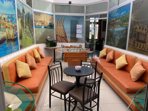 a coffee shop with orange couches and a table and chairs at Lima House Hostel in Lima
