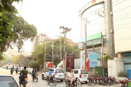 Un groupe de personnes voyageant à moto dans une rue urbaine animée dans l'établissement Hotel Pace Inn, à Multan