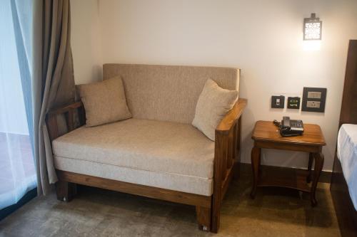 a chair in a room with a bed and a table at Altrude By The Sea in Candolim