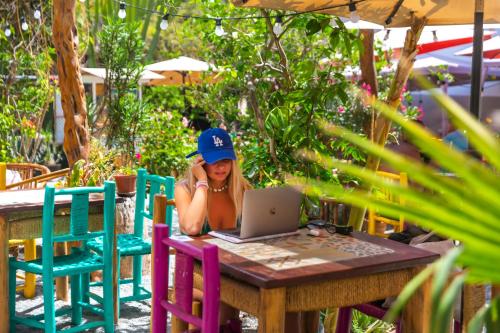 a girl sitting at a table with a laptop at Banana's Adventure Hostel in Ica