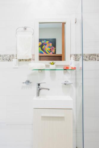 a white bathroom with a sink and a mirror at Casa Mariano in Morelia