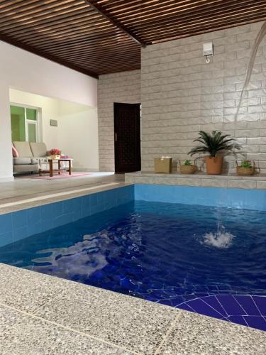 a swimming pool with blue water in a house at Oriental Nights Rest House in Al Wāşil