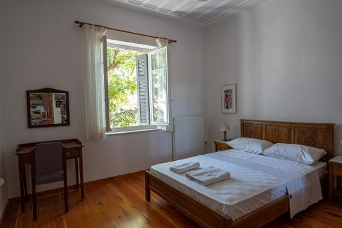 a bedroom with a bed and a window and a table at A Painter's House in Plaka in Athens
