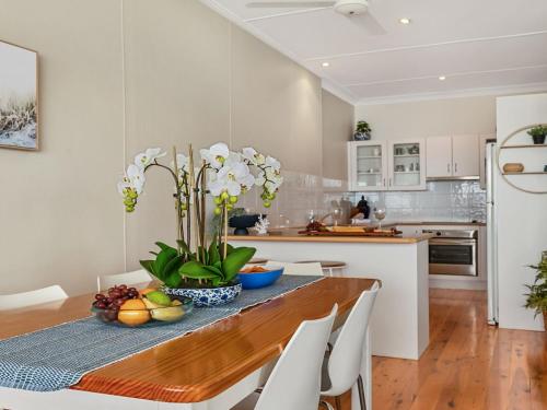 a kitchen with a wooden table and white appliances at Ocean Blue Apartment Two in Currarong