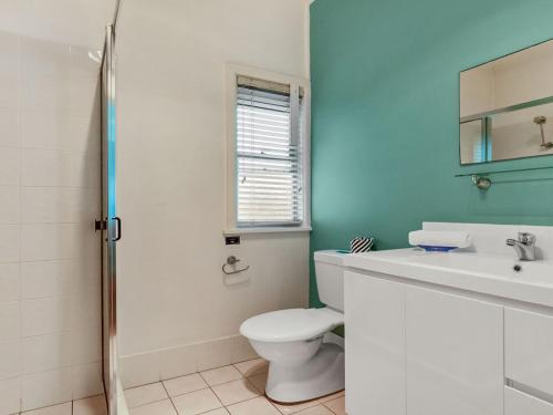 a bathroom with a toilet and a sink and a window at Ocean Blue Apartment Two in Currarong