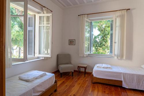 a bedroom with two beds and two windows at A Painter's House in Plaka in Athens