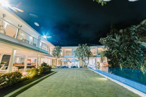 ジンバランにあるCassaMia Bali - Spacious Luxury 5 Bedroom Villaの夜間のスイミングプール付きの家の外観